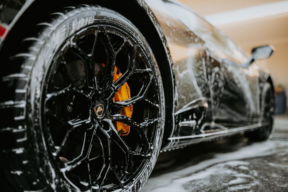 Premium car wash applying foam to a luxury vehicle